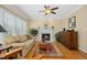 Inviting living room with fireplace, hardwood floors, ceiling fan and natural light at 1109 Frenchurch Way, Apex, NC 27502