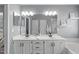 Well-lit bathroom features double sinks, white cabinetry, framed mirror, and gray walls at 11228 N Radner Way, Raleigh, NC 27613