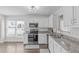 Bright kitchen featuring white cabinets, granite countertops, and stainless steel appliances at 11228 N Radner Way, Raleigh, NC 27613