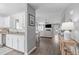 Open-concept living space with hardwood floors, a white kitchen, and a comfortable seating area at 11228 N Radner Way, Raleigh, NC 27613