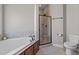 Bathroom featuring a soaking tub, tiled shower with glass door, and modern commode at 121 Starlight Dr, Lillington, NC 27546