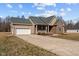 Well-maintained home featuring a two-car garage, a large driveway, and complemented by verdant landscaping at 121 Starlight Dr, Lillington, NC 27546