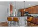 Open kitchen boasts wood cabinets, granite counters, island seating, and modern lighting at 121 Starlight Dr, Lillington, NC 27546