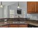 Kitchen sink with granite countertops, opens to view of the living room and fireplace at 121 Starlight Dr, Lillington, NC 27546