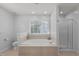 Elegant bathroom with a large soaking tub, separate glass-enclosed shower, and tiled surround at 1233 Dunn Creek Xing, Wake Forest, NC 27587