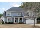 Charming two-story home featuring a well-manicured lawn and a classic covered front porch with rocking chairs at 1233 Dunn Creek Xing, Wake Forest, NC 27587
