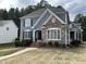 Charming two-story home featuring stone accents, blue siding, and a well-manicured front yard at 1233 Dunn Creek Xing, Wake Forest, NC 27587