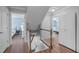 Bright upstairs hallway with wood floors, and staircase leading to bedrooms and bathrooms at 1233 Dunn Creek Xing, Wake Forest, NC 27587