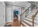 Spacious hallway with hardwood floors, white trim, views into the office and traditional staircase with wooden banister at 1233 Dunn Creek Xing, Wake Forest, NC 27587