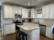 Bright kitchen with stainless steel appliances, granite countertops, and a central island with bar stool seating at 1233 Dunn Creek Xing, Wake Forest, NC 27587