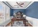 Stylish home office featuring classic blue walls, plantation shutters, a ceiling fan and built in bookshelves at 1233 Dunn Creek Xing, Wake Forest, NC 27587