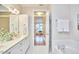 Bright bathroom featuring a double sink vanity, soaking tub, and an open doorway to the bedroom at 200 S Dawson St # 303, Raleigh, NC 27601