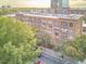 Brick building exterior with white framed windows and balconies overlooking tree-lined street in urban setting at 200 S Dawson St # 303, Raleigh, NC 27601