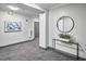 Well-lit hallway with neutral colors, modern artwork, and a round mirror over a console table with decor at 200 S Dawson St # 303, Raleigh, NC 27601