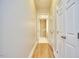 Hallway with wood floors leading to a bathroom with white finishes at 200 S Dawson St # 303, Raleigh, NC 27601