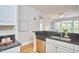 Modern kitchen with stainless steel dishwasher, black countertop, and view to outdoor balcony at 200 S Dawson St # 303, Raleigh, NC 27601