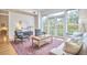 Bright living room with balcony access, stylish furniture, and a colorful rug on hardwood floors at 200 S Dawson St # 303, Raleigh, NC 27601