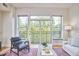 Bright living room with balcony access, stylish furniture, and a colorful rug on hardwood floors at 200 S Dawson St # 303, Raleigh, NC 27601