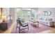 Bright living room with balcony access, stylish furniture, and a colorful rug on hardwood floors at 200 S Dawson St # 303, Raleigh, NC 27601
