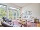 Cozy living room with a comfortable sofa, chairs, and large windows with balcony access, wood floors and stylish decor at 200 S Dawson St # 303, Raleigh, NC 27601