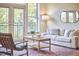Bright living room with a comfortable sofa and large windows with balcony access, wood floors and stylish decor at 200 S Dawson St # 303, Raleigh, NC 27601