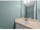 Bright bathroom featuring a vanity with sink, a mirror, and blue walls at 209 Intern Way, Durham, NC 27713