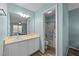 Bathroom with a single sink vanity and a shower-tub combo with blue accent wall at 209 Intern Way, Durham, NC 27713