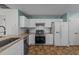Clean kitchen featuring white cabinets, granite countertops, and stainless steel appliances at 209 Intern Way, Durham, NC 27713