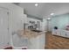 Bright kitchen with white cabinets, granite countertops, and barstool seating at the counter at 209 Intern Way, Durham, NC 27713