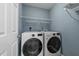 Efficient laundry room featuring side-by-side washer and dryer and ample shelving at 209 Intern Way, Durham, NC 27713