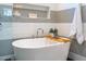 Close up of soaking tub with decor, tiled accent wall, and modern fixtures at 2109 Meadowcreek Dr, Durham, NC 27705