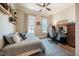 Bright bedroom with a cozy bed, two windows with curtains, a ceiling fan, and a wooden desk with a computer at 2109 Meadowcreek Dr, Durham, NC 27705