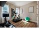 A bright exercise room with a treadmill, rowing machine, accent artwork and two windows for lots of natural light at 2109 Meadowcreek Dr, Durham, NC 27705