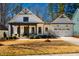 Charming two-story home with white siding, black trim, covered porch, and well-manicured landscaping at 2109 Meadowcreek Dr, Durham, NC 27705