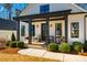 Inviting front porch with dark columns, seating, and stylish decor for relaxing outdoor enjoyment at 2109 Meadowcreek Dr, Durham, NC 27705