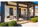 Inviting front porch featuring dark columns, cozy seating, and brick-paved steps for a warm welcome at 2109 Meadowcreek Dr, Durham, NC 27705