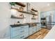 Well-appointed kitchen features stainless steel appliances, light blue cabinets, open shelving, and hardwood floors at 2109 Meadowcreek Dr, Durham, NC 27705
