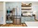 Charming kitchen features stainless steel appliances, light blue cabinetry, and decorative wood shelving at 2109 Meadowcreek Dr, Durham, NC 27705