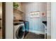 Well-organized laundry room featuring a modern washer and dryer, shelving, and attractive wallpaper at 2109 Meadowcreek Dr, Durham, NC 27705