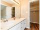Bathroom with a double vanity, large mirror, wood floors and access to a walk-in closet with built-in shelves at 212 Walnut Creek Dr, Clayton, NC 27520
