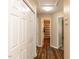 A hallway featuring wood flooring, neutral paint, white trim, a closet, and access to the bathroom with a shower and tub at 212 Walnut Creek Dr, Clayton, NC 27520
