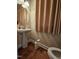 Small bathroom with pedestal sink, framed mirror, toilet, neutral colors, and a fabric window shade at 2132 Royal Berry Ct, Cary, NC 27511