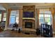 Living room showcasing a stone fireplace, large windows, and neutral color scheme at 2132 Royal Berry Ct, Cary, NC 27511