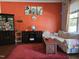 Bright living room with sofa, display cabinet, wood floors, and red accent wall at 2132 Royal Berry Ct, Cary, NC 27511