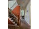 Staircase with carpeted steps, dark iron railing, and colorful accent wall in the home's interior at 2132 Royal Berry Ct, Cary, NC 27511