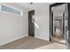 Bedroom with hardwood floors, black door, and a window overlooking the neighborhood at 226 Woodsborough Pl, Raleigh, NC 27601