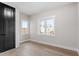 Bright bedroom with hardwood floors, a dark closet door, and dual windows at 226 Woodsborough Pl, Raleigh, NC 27601