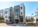 Modern townhomes with gray and white exterior paint, black trim, and a small yard at 226 Woodsborough Pl, Raleigh, NC 27601