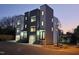 Modern townhomes feature clean lines, neutral colors, and large windows, complemented by sleek metal railings and ample lighting at 226 Woodsborough Pl, Raleigh, NC 27601