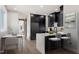 Modern kitchen with sleek black cabinetry, stainless steel appliances, and a waterfall island with seating for two at 226 Woodsborough Pl, Raleigh, NC 27601